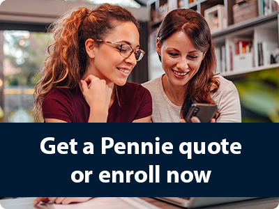 A photo of two smiling white women looking at a cell phone and laptop.